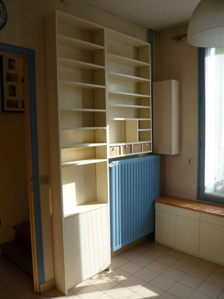 Aménagement sur mesure avec bibliothèque et rangements autour du radiateur