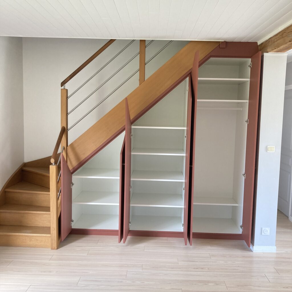 Placard sous escalier ouvert avec étagères et penderie