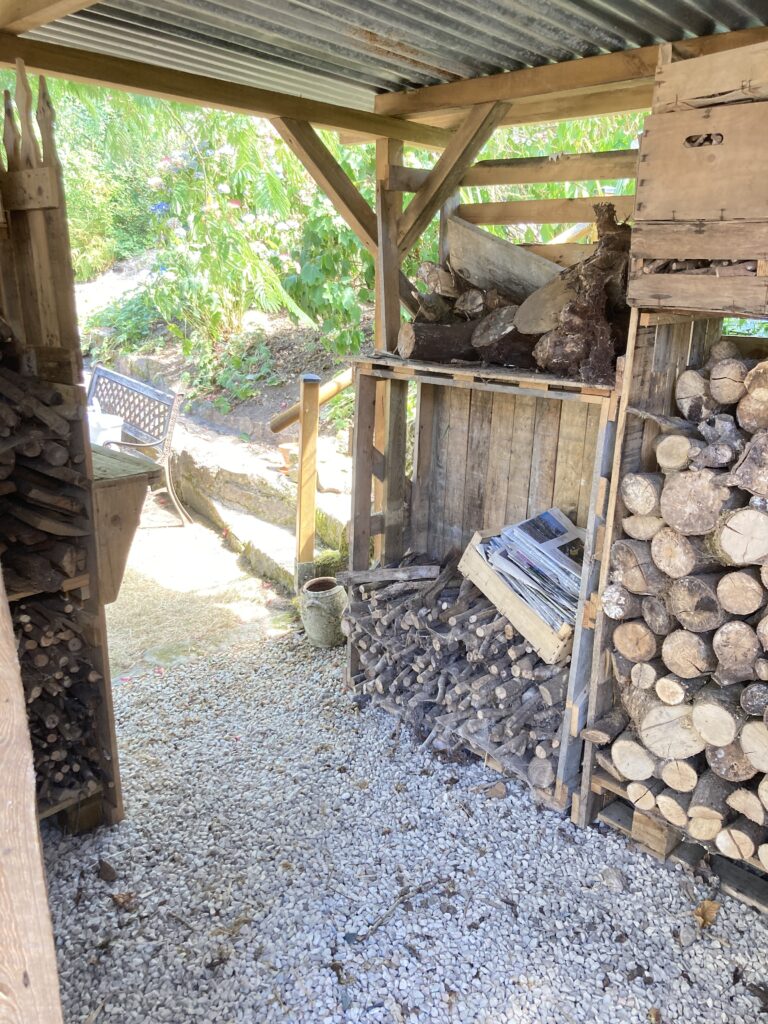 Petit abri à bois réalisé avec des matériaux de réemploi