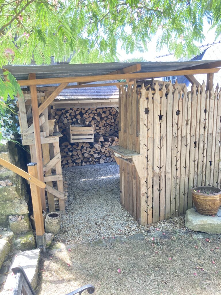 Abri à bois réalisé avec des matériaux de récupération
